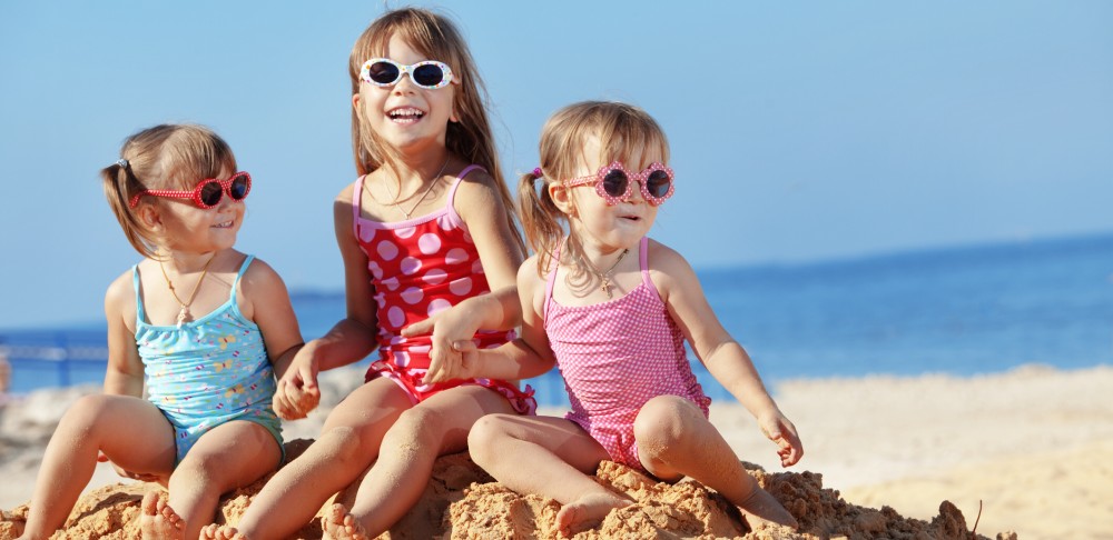Three girls with sunglasses on beach